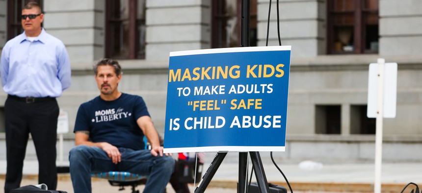 A sign at an October 2021 Moms for Liberty rally at the Pennsylvania state Capitol compares school mask mandates to child abuse. About 100 people attended the rally to protest mask and vaccine mandates.