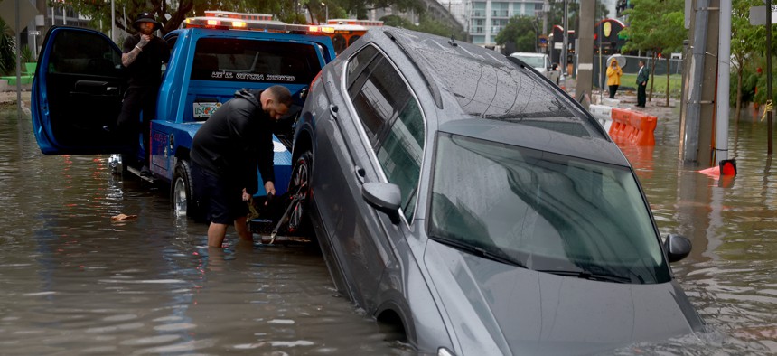 A vehicle is prepared to be towed after it died while being driven through a flooded street caused by a deluge of rain on June 4, 2022 in Miami. 