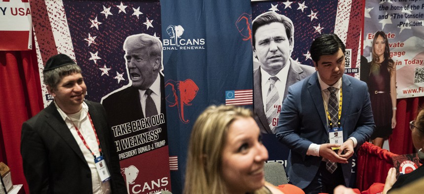 Posters of former President Donald Trump and Florida Gov. Ron DeSantis are seen during the first day of the Conservative Political Action Conference (CPAC) on Thursday, Feb. 24, 2022 in Orlando. 
