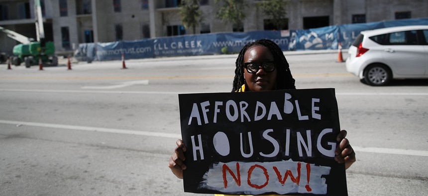In this 2017 file photo, Daniella Pierre joins other protesters across the street from a condo that is being built as they ask for affordable housing in South Florida. 