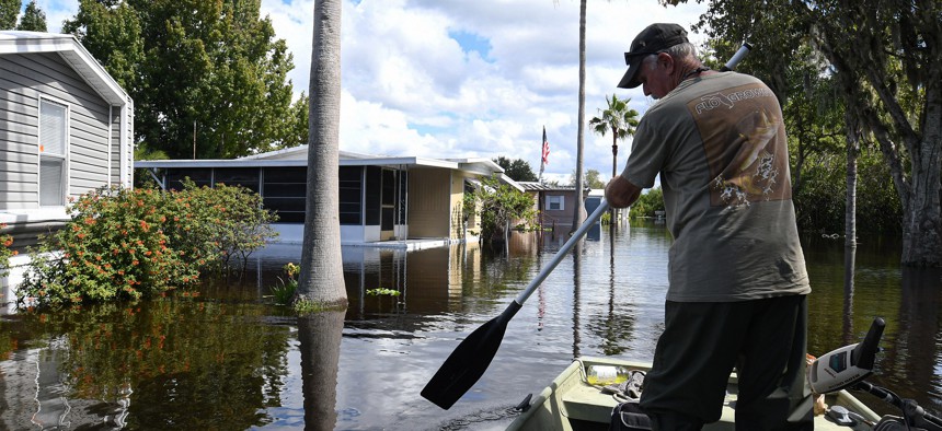 Kit Brown paddles his boat in a flooded street near his home in the Jade Isle Mobile Home Park in St. Cloud. Residents of the community were issued a voluntary evacuation order due to rising water levels in the aftermath of Hurricane Ian.