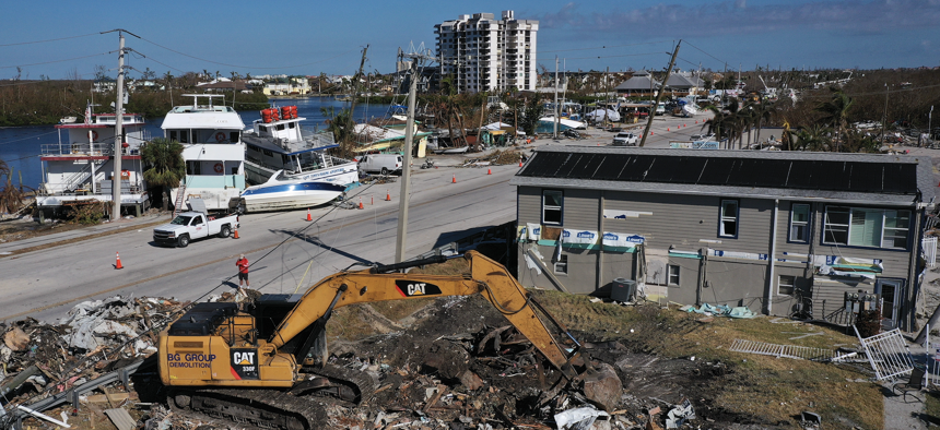 An excavator is used to clear debris left in the wake of Hurricane Ian on October 06, 2022 on San Carlos Island, Florida. The removal of destroyed homes, cars, and related debris across southwest Florida is expected to take months.