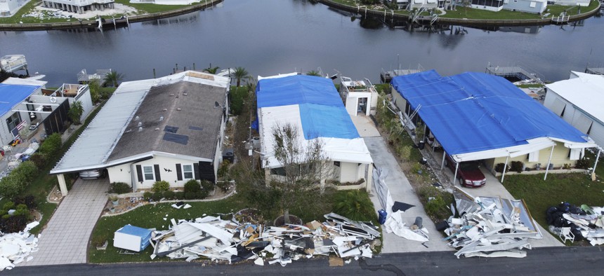 Cleanup is underway in North Port on Wednesday, Oct. 12, after Hurricane Ian raked a path of destruction across the southeast United States, devastating the state of Florida and its Gulf Coast. Homeowners cover the damaged roofs with blue tarps to keep the interior dry until a new roof can be installed. 