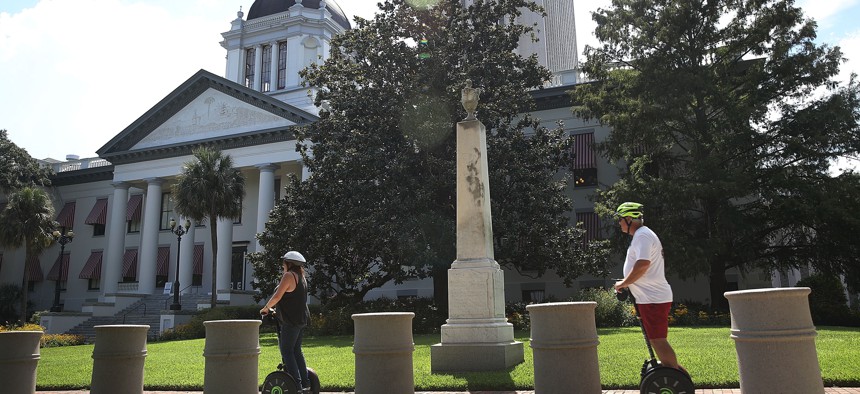 People on scooters pass in front of Florida's Historic Capitol in Tallahassee. 
