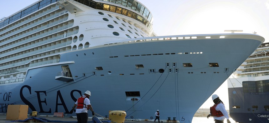 Dock workers use ropes to tie the Royal Caribbean’s Odyssey of The Seas to its berthing spot at Port Everglades on June 10, 2021. 