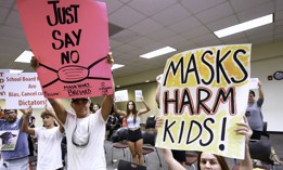 In this August 2021 file photo, people demonstrate with placards at an emergency meeting of the Brevard County School Board to discuss whether face masks in local schools should be mandatory. 