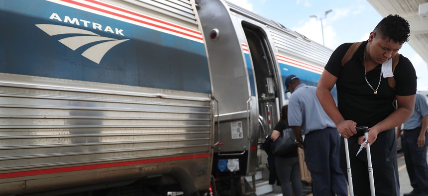 Passengers board an Amtrak train at the Miami station in this 2017 file photo.