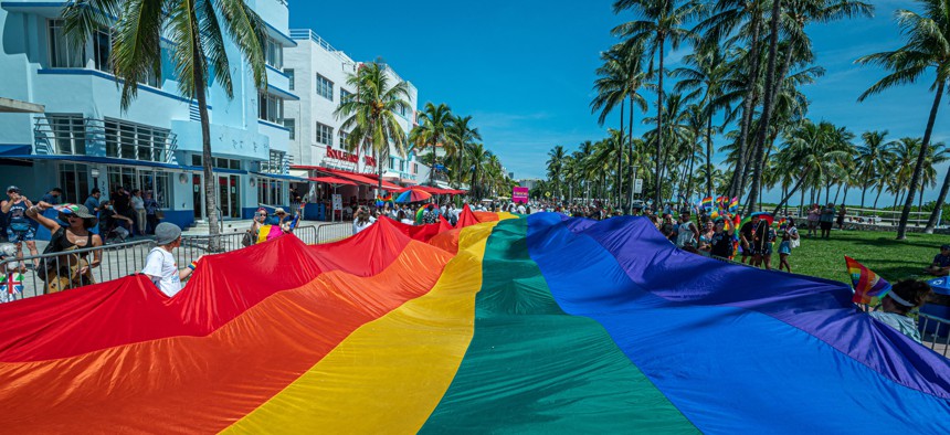 A huge multi-colored flag flies over Ocean Drive as people participate in the Pride Parade, during the Miami Beach Pride Festival, in Lummus Park, South Beach, on Sept. 19, 2021. 