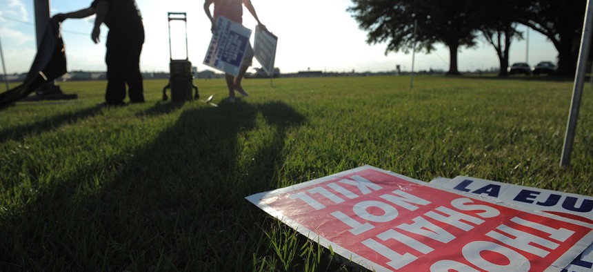 People opposed to the death penalty pick up signs as they gathered to demonstrate against the execution of John Ruthell Henry near Florida State Prison on June 18, 2014 in Raiford.