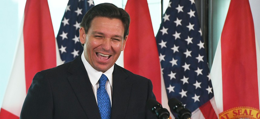 Florida Gov. Ron DeSantis laughs during a press conference to announce the Moving Florida Forward initiative at the SunTrax Test Facility in Auburndale.