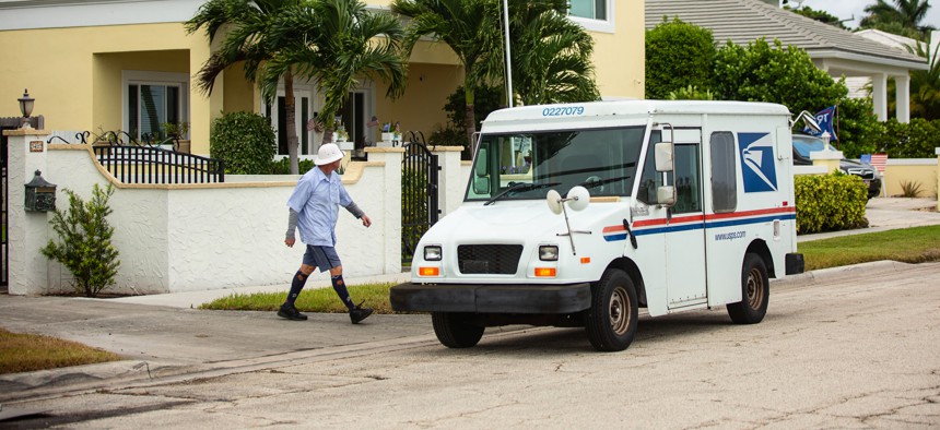 A letter carrier delivers mail to a West Palm Beach home.