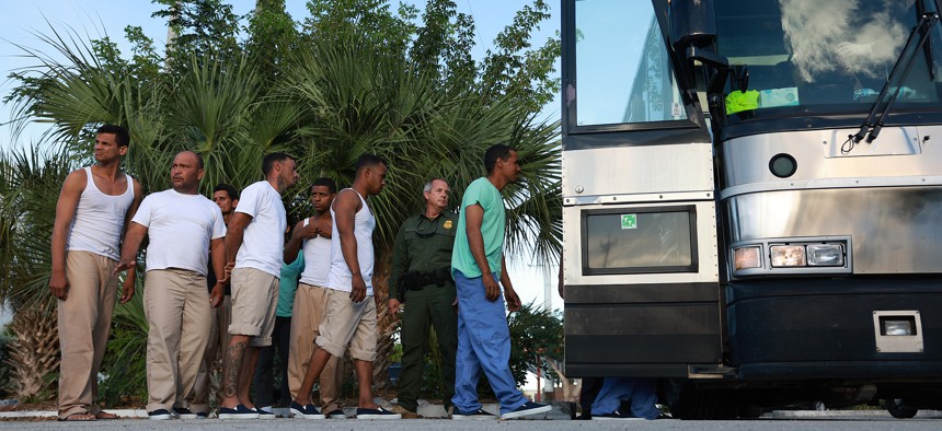 Migrants from Cuba line up to board a bus to be driven to a U.S. Customs and Border Protection station as they are processed on Jan. 5, 2023 in Marathon.