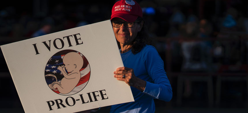 A woman holds a pro-life sign before Gov. DeSantis spoke to supporters at a Unite and Win rally at OCC Roadhouse & Museum in Clearwater, Nov. 5, 2022.