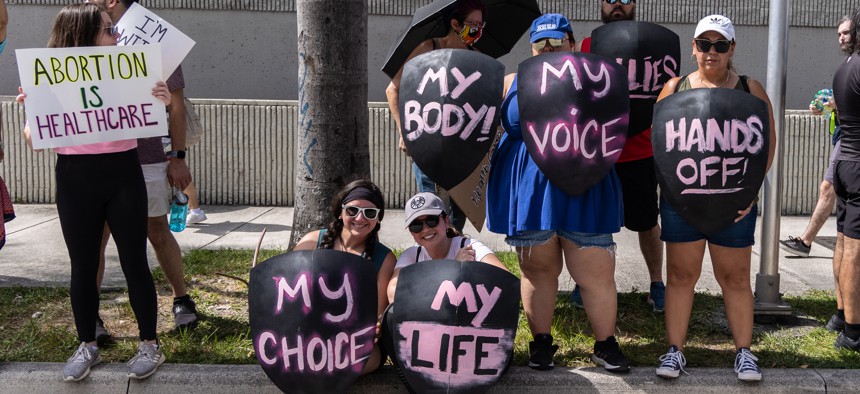 Abortion rights activists hold signs at a protest in support of abortion access on July 13, 2022 in Fort Lauderdale.