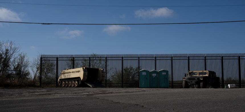 Military vehicles are seen in front of the border wall in Del Rio, Texas on March 5, 2023. 
