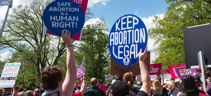 Activists hold abortion rights signs and shout slogans while joining in a rally outside the U.S. Supreme Court, April 15, 2023. 