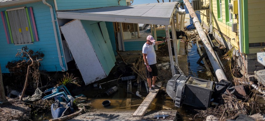 A man stands in front of his destroyed house in the aftermath of Hurricane Ian in Matlacha, Oct. 3, 2022. 