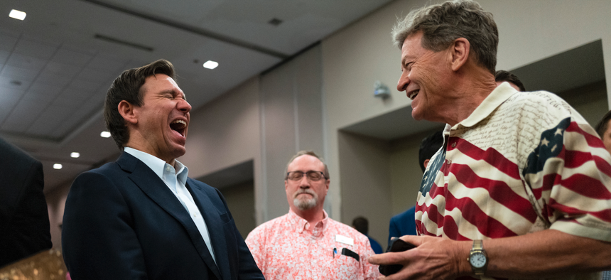 DeSantis (at left) speaks with attendees during an Iowa GOP reception on May 13, 2023 in Cedar Rapids, Iowa. 