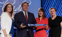 DeSantis receives a ceremonial 'Liberty Sword' at last year's Moms for Liberty national summit in Tampa, Florida. 