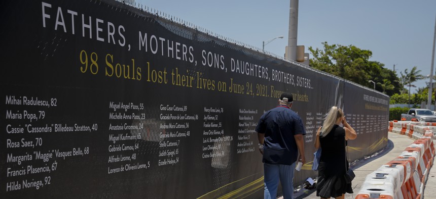 People walk past a temporary memorial wall at the site during a Surfside Remembrance Event for the collapse of the 12-story Champlain Towers South condo building on June 24, 2022 in Surfside. 