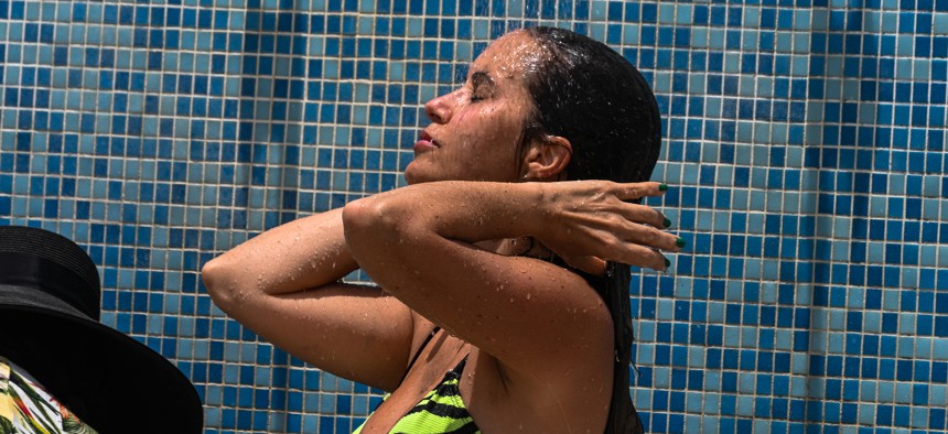 A woman rinses off after going to the beach during an intense heat wave in Miami Beach on July 16, 2023. The National Weather Service warned of an "extremely hot and dangerous weekend," with daytime highs reaching up to 116 degrees F (47 C).
