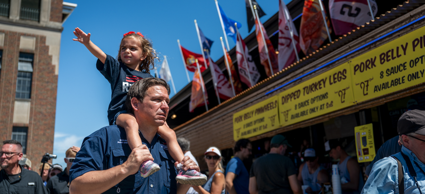 Republican presidential candidate and Florida Gov. Ron DeSantis carries his daughter Madison while walking through the Iowa State Fair on August 12, 2023 in Des Moines, Iowa. 