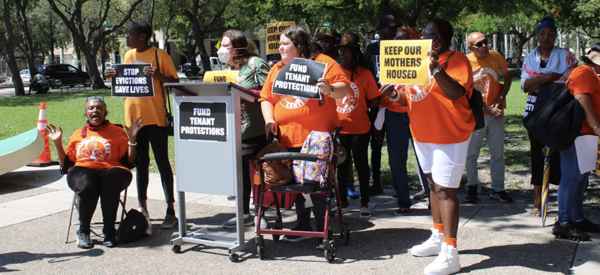 Members of the Miami Workers Center, along with supporters and tenants, gather behind a podium with a sign that reads "Fund Tenant Protections," Thursday, Sept. 7, 2023.